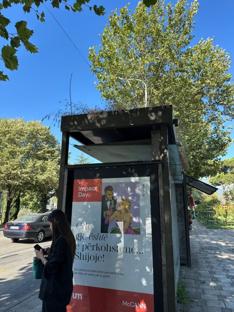 A bus station billboard in Tirana displays a cheerful message with Impact Day branding, part of UM Tirana’s campaign to uplift the public and inspire positive thinking in high-traffic urban areas.